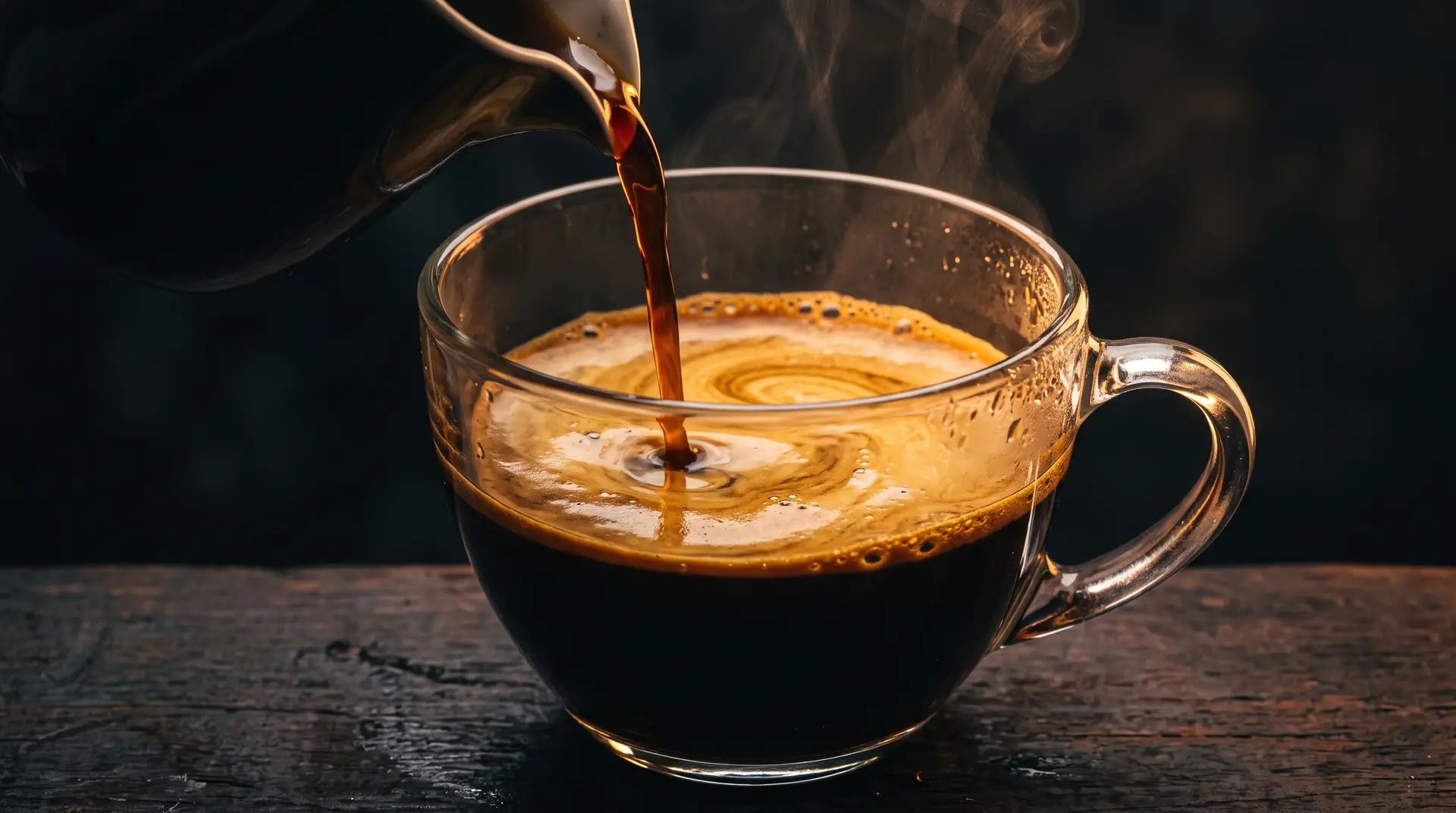Coffee pouring into a glass cup with thick golden crema